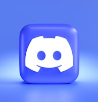 A three-dimensional blue cube featuring a white, stylized gaming controller symbol associated with a popular communication platform, set against a gradient blue background.